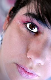 Nahaufnahme eines Gesichts mit kreativem, buntem Make-up, das die künstlerische Vielfalt und Handwerkskunst bei HANDMADE Kultur betont.