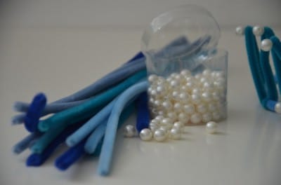 Bunte Bastelmaterialien, Perlen und Schläuche für kreative Meerjungfrau-Krönchen, ideal für Handarbeit und DIY-Projekte.