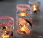 zarte Windlichter mit Hornveilchen und Federn