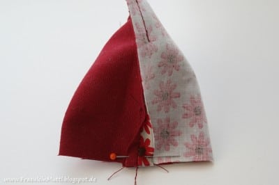 Selbstgenähte Stoffkappe mit rotem und gemustertem Stoff, ideal für Kinder, im Rahmen eines Näh-Tutorials für das Nähen eines Küken-Kopfes.