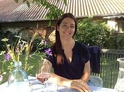 Frau beim Essen im Garten, umgeben von Blumen und Natur, bei Handmade Kultur Veranstaltung, entspannt und glücklich, sommerliches Ambiente, kreative Atmosphäre.