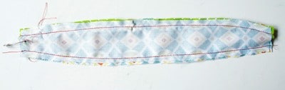 Stoffstreifen mit Paspel, Henkel und Schleife für Nähprojekte, detailreiche Nahaufnahme, handgefertigt, kreative Bastelarbeit, textile Dekoration.