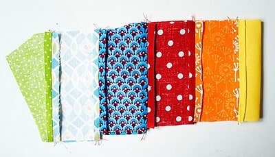 Verschiedene bunte Stoffe in Mustern und Farben, ideal für Näharbeiten und kreative Projekte.