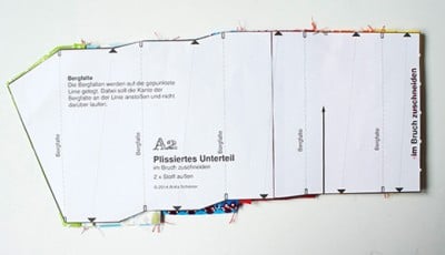 Schnittmuster für ein Plissee-Unterteil mit Markierungen und Anleitungen für den Nähprozess.