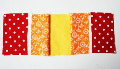 Bunte Stoffe in Rot, Orange und Gelb für Nähprojekte wie Plissee und Innentasche, ideal für Sew Along Tag 3 bei HANDMADE Kultur.