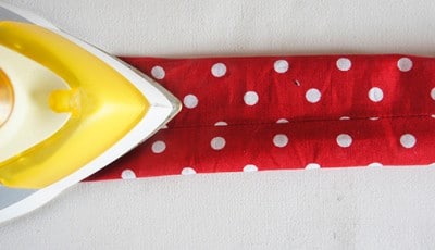 Rotes Stoffband mit weißen Punkten, ideal für Nähprojekte, Dekorationen und Handarbeiten, passend zum Thema Sew Along Tag 2 - Paspel, Henkel und Schleife.