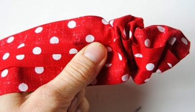 Rote Stoffschleife mit weißen Punkten, handgehalten, für Nähprojekte und Dekorationen bei Handmade Kultur.