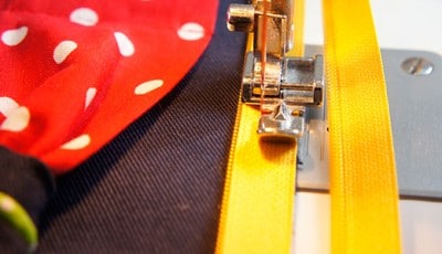 Nähen einer Clutch mit Nähmaschine, Stoffen und Reißverschluss, Fokus auf Handarbeit und Kreativität für das Sew Along Tag 4.
