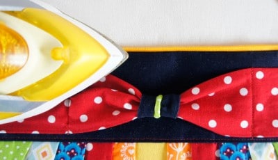 Bunte Clutch mit rotem Polka-Dot-Design, schwarzem Band und bunten Stoffdetails, perfekt für den Sew Along Tag 4 - Clutch zusammenstellen.