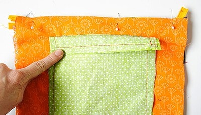 Nähen einer Clutch mit grünem Stoff und orangefarbenem Außenstoff, Schritt für Schritt beim Sew Along Tag 4 - Clutch zusammenstellen.