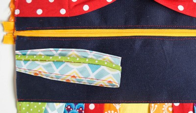 Bunte Stoffe und Reißverschluss für eine selbstgenähte Clutch, passend zum Sew Along Tag 4 - Clutch zusammenstellen, mit Fokus auf Nähzubehör und kreative Gestaltung.
