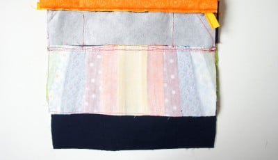 Stoffzuschnitt für Clutch mit bunten Stoffen, Nähfaden und Schnittmuster für Handarbeit und DIY-Projekte bei Handmade Kultur.