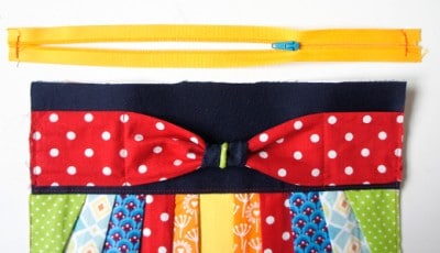 Reißverschluss und bunte Stoffe für die Herstellung einer Clutch, passend zum Sew Along Tag 4 - Clutch zusammenstellen, mit Fokus auf Nähzubehör und Stoffdesigns.