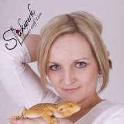 Frau mit blondem Haar hält einen orangefarbenen Leguan, symbolisiert Kreativität und Naturverbundenheit, im Zusammenhang mit Handmade Kultur und nachhaltigem Handwerk.