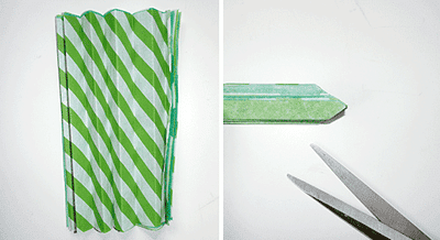Grüne und weiße Papierstreifen, Schere und Holzstab für DIY Wabenbälle und Pompoms zum Selbermachen, kreative Bastelmaterialien für Dekorationen.
