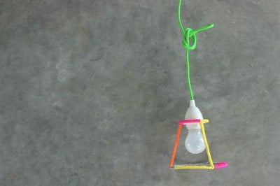Selbstgemachter Lampenschirm aus bunten Häkelringen, aufgehängt an einer grünen Schnur, kreative Beleuchtungsidee für DIY-Projekte.