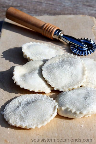 Frische handgemachte Ravioli auf einer Arbeitsfläche, mit Nudelholz und Mehl, ideal für hausgemachte italienische Küche, perfekt für das Thema Handmade Kultur.