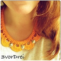 Handgefertigter Häkelkragen in Orange mit silbernen Nieten, Teil eines kreativen Schmuckdesigns für Handmade Kultur.