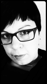 Nahaufnahme eines Porträts einer Frau mit schwarzen Haaren und Brille, die für Handmade Kultur fotografiert wurde, Fokus auf Gesicht und Ausdruck.