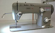 Alte Nähmaschine Nadel 705 H mit Bedienknöpfen und Spulenkapsel, ideal für Handarbeit und Textilgestaltung.