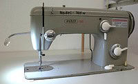 Alte Nähmaschine Nadel 705 H mit Bedienknöpfen und Spulenkapsel, ideal für Handarbeit und Textilgestaltung.