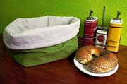 Selbstgemachter Brotkorb und Utensilo aus Stoff, perfekt für die Küche, mit Gewürzstreuern und Brötchen auf einem Holztablett.