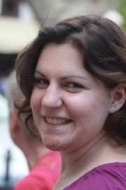Lächelnde Frau mit braunen Haaren und lila Oberteil bei Handmade Kultur Veranstaltung, kreative Atmosphäre, Gemeinschaft, Handwerkskunst, Freude, Event, Outdoor.