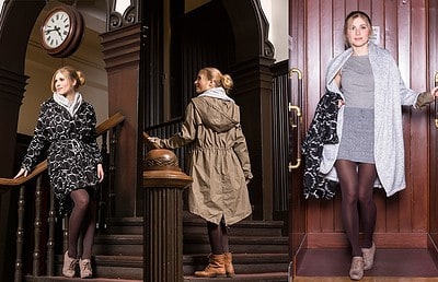 Drei Frauen in stilvoller Winterkleidung, die im Eingangsbereich eines historischen Gebäudes stehen, mit Uhren und Holzvertäfelung im Hintergrund.