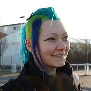 Frau mit buntem, kreativen Haarschnitt in lebendigen Farben, die handgemachte Kultur und kreative Mode repräsentiert, ideal für DIY- und Handwerkskunst-Content.