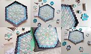 Handgefertigte Hexagon Patchwork Tischdecke aus Stoff in Pastellfarben mit schwarzen Akzenten, umgeben von Nähzubehör und Stoffresten, ideal für kreative Heimdekoration.