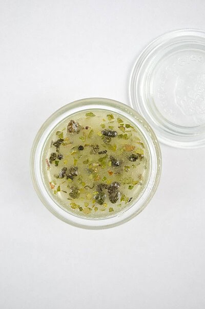 Handmade Kultur Grüntee-Mate-Peeling mit grünen Teeblättern und Peeling-Partikeln in einem Glasbehälter, ideal für natürliche Hautpflege.