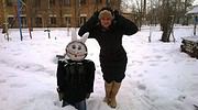 Frau mit Winterkleidung und Kind in Schneelandschaft, handgemachte Winterdekoration, kreative Handwerkskunst, Outdoor-Handwerkskunst, winterliche Handarbeit, Handmade Kultur.