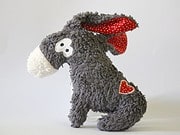 Kuscheltier-Esel aus weichem, grauem Plüsch mit roten Details, Herz auf dem Bauch und lustigem Gesicht, ideal für Kinder und als Dekoration im Handmade-Stil.