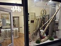 Kunsthandwerkliche Dekorationen und handgefertigte Innenelemente in einem Geschäft, inklusive Birkenstämme, Stoffe und Pflanzen, für kreative Raumgestaltung.