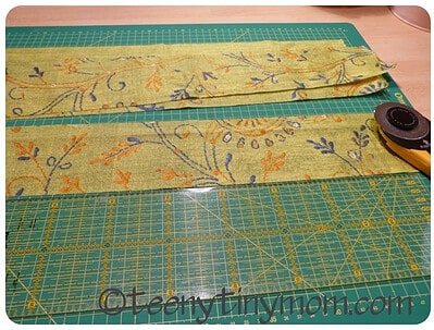 Bunte Stoffreste mit Stickerei, Schneidematte und Rollschneider für Näharbeiten, kreative Handarbeit, Textilgestaltung, DIY-Projekt, Handmadekultur.