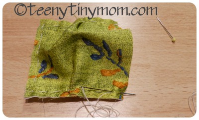 Nähen eines Stoffstücks mit grüner Wolle, Nadeln und Faden, kreative Handarbeit, DIY, Textilkunst, Handarbeit, Basteln, Nähzubehör, Handgemacht, kreative Tätigkeit.
