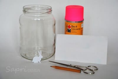 Leeres Glas, rosa Sprühfarbe, Schere, Bleistift und Papier für Osterhasen-Windlicht Bastelprojekt.