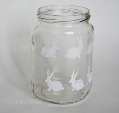Transparentes Glaswindlicht mit weißen Osterhasenmotiven, ideal für Frühlings- und Osterdekorationen, handgemacht und vielseitig einsetzbar.