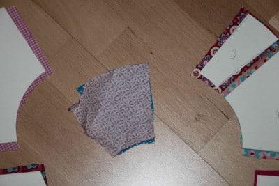 Bunte Papierstücke und Bastelmaterialien für einen Frühlingskranz, kreative Handarbeit, DIY Dekoration, Frühlingsdeko, Papierbastelei, Handarbeit, kreative Bastelideen.