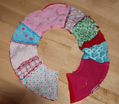 Bunter Stoffkranz aus verschiedenen Stoffmustern und Farben, ideal für Frühlingsdekoration, handgemacht, kreative Bastelarbeit.