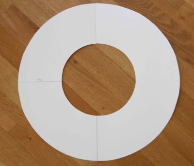 Leere weiße Kreise aus Papier, ideal für die Gestaltung eines Frühlingskranzes, auf Holztisch gelegt, zum Basteln und Dekorieren geeignet.