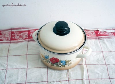 Vintage Gänseblümchen Sirup Flasche mit Deckel auf einem Stofftuch, ideal für hausgemachte Siruprezepte.