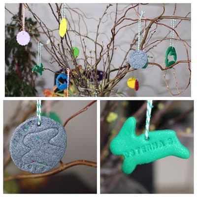 Bunte Osteranhänger aus Fimo in verschiedenen Formen und Farben, an Zweigen aufgehängt, ideal für Osterdekoration und kreative Bastelideen.