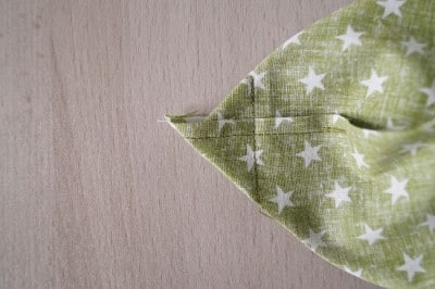 Grüner Stoffbeutel mit weißen Sternen, handgenäht, für Ostergeschenke oder Dekoration, passend zum Thema Osterbeutel mit Applikation nähen.