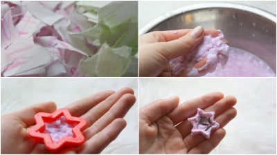 Hand beim Herstellen eines Papiersterns mit Saatfüllung, der für Bastel- und Gartenprojekte geeignet ist, auf einem weißen Hintergrund.