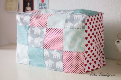 Handgemachte Patchwork-Abdeckung für Nähmaschine mit bunten Stoffmustern, ideal für Nähzubehör und Schutz der Maschine.