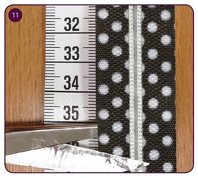 Stoff mit schwarzen Polka-Dots auf weißem Hintergrund, Reißverschluss, Messlineal zeigt 33-35 cm, für kreative Nähprojekte bei HANDMADE Kultur.