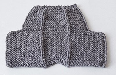 Handgestrickte Hausschuhe aus grauem Garn, perfekt für gemütliche Tage zu Hause, hergestellt mit weicher Wolle und liebevoller Handarbeit.