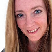 Porträt einer lachenden Frau mit blauen Augen und langen roten Haaren, die Freude und Kreativität ausstrahlt, passend für Handmade Kultur und kreative Handwerkskunst.