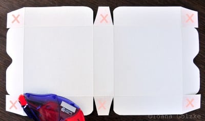 Weiße Geschenk- oder Pizzabox aus Karton, offen mit Klappdeckel, ideal für Cookies oder kleine Geschenke, auf dunklem Holzuntergrund.